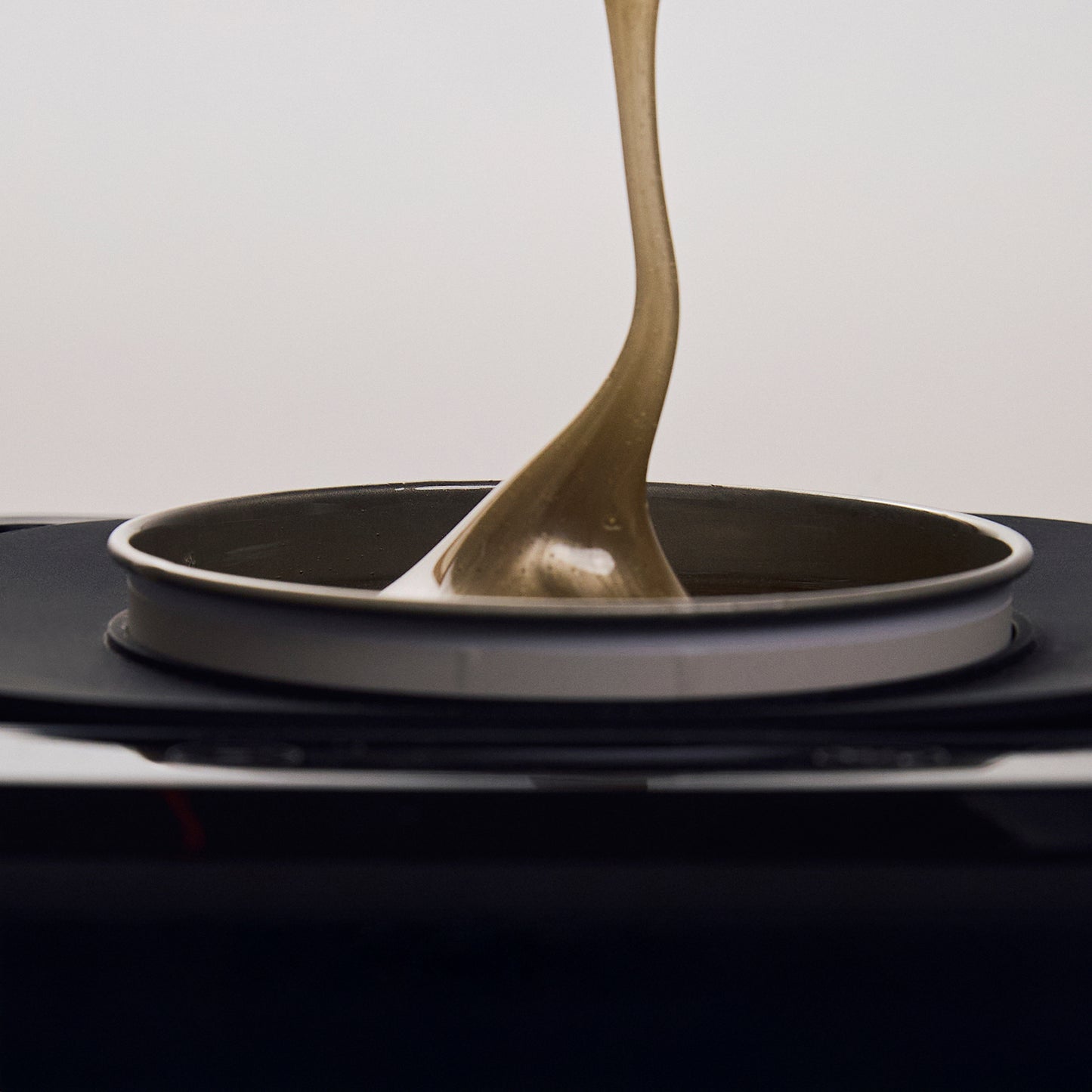 Close-up image of Brow Code’s Wax Collar fitted around a wax warmer, preventing wax drips and keeping the station clean